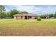 Single-story home featuring solar panels and a well-manicured front lawn at 10631 W Highway 40, Ocala, FL 34482