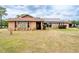 Inviting single-story home with stone accents, solar panels, and a well-maintained lawn at 10631 W Highway 40, Ocala, FL 34482