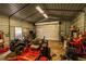 A garage full of toys and tools with overhead lighting and a roll up door at 10631 W Highway 40, Ocala, FL 34482