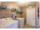 Functional laundry room with washer and dryer, shelving, tile floor and white walls at 10631 W Highway 40, Ocala, FL 34482