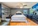 Main bedroom features a large comfortable bed, accent furniture, ceiling fan and wood floors at 10631 W Highway 40, Ocala, FL 34482