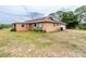 View of the home's rear exterior, showcasing the attached garage, siding, and backyard at 10631 W Highway 40, Ocala, FL 34482