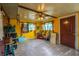 The room has yellow walls, a concrete floor, a ceiling fan, two windows, and some clutter at 10631 W Highway 40, Ocala, FL 34482