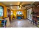 The room has yellow walls, a concrete floor, a ceiling fan, a window, and some clutter at 10631 W Highway 40, Ocala, FL 34482