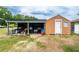 A shed with an overhang is on a lot that is in need of some lawn care at 10631 W Highway 40, Ocala, FL 34482