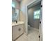 Bright bathroom boasts marble floors, white vanity with black hardware, and separate toilet room at 13081 Sw 78Th Cir, Ocala, FL 34473