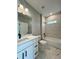 Bathroom features a shower over tub combo, white vanity with a dark faucet, and large mirror at 13081 Sw 78Th Cir, Ocala, FL 34473