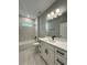 Bathroom features a shower over tub, white vanity, and large mirror at 13081 Sw 78Th Cir, Ocala, FL 34473