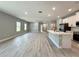 This open layout has an eat-in kitchen and living room with neutral colors and wood-look floors at 13081 Sw 78Th Cir, Ocala, FL 34473