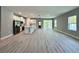 Bright, open-concept living area featuring modern finishes, wood-look floors, and lots of natural light at 13081 Sw 78Th Cir, Ocala, FL 34473