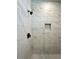 Close-up of the shower, featuring stylish marble-look tile, black fixtures, and built-in niche at 13081 Sw 78Th Cir, Ocala, FL 34473