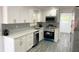 Modern kitchen featuring white cabinetry, stainless steel appliances, and quartz countertops at 1335 Ne 10Th St, Ocala, FL 34470