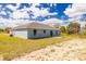 Rear exterior of home and yard, showing a concrete patio and sliding glass doors at 13493 Sw 112 Pl, Dunnellon, FL 34432