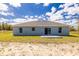 The back exterior of the home, featuring a concrete patio and sliding glass door at 13493 Sw 112 Pl, Dunnellon, FL 34432