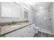 Bathroom featuring double sinks with granite countertops and a walk-in shower with marble tiling at 13493 Sw 112 Pl, Dunnellon, FL 34432