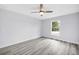 Bright bedroom with grey flooring and a window with a view of the outdoors and ceiling fan at 13493 Sw 112 Pl, Dunnellon, FL 34432