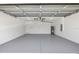 View of spacious two car garage with white walls and sealed concrete floor at 13493 Sw 112 Pl, Dunnellon, FL 34432