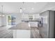 Light and airy kitchen features white cabinets, stainless steel appliances, and a granite island at 13493 Sw 112 Pl, Dunnellon, FL 34432