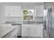 Close-up of bright kitchen features white cabinets, stainless steel appliances, and a granite countertop at 13493 Sw 112 Pl, Dunnellon, FL 34432