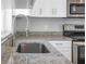 Kitchen area featuring stainless steel sink, modern faucet, and granite countertops at 13493 Sw 112 Pl, Dunnellon, FL 34432