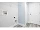 A well-lit laundry room with gray wood-look floors and door to exterior at 13493 Sw 112 Pl, Dunnellon, FL 34432