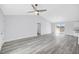 Spacious open floor plan features wood-look floors, a ceiling fan, and large sliding glass doors at 13493 Sw 112 Pl, Dunnellon, FL 34432