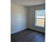 A bright bedroom features wood-look floors and a window providing natural light at 14437 Sw 21St Pl, Ocala, FL 34481