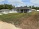 Charming single-story home featuring a manicured lawn, attached garage, and inviting front entrance at 14437 Sw 21St Pl, Ocala, FL 34481