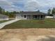 Charming single-story home featuring a manicured lawn, attached garage, and inviting front entrance at 14437 Sw 21St Pl, Ocala, FL 34481
