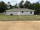 Exterior of home with lush green backyard, irrigation, and a white door at 21 Pl # 14443, Ocala, FL 34481