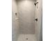 Modern walk-in shower featuring marble-look tiling, matte black fixtures, and built-in niche at 21 Pl # 14443, Ocala, FL 34481