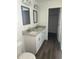 Bathroom with double sinks, granite countertops, dark floors and white cabinets at 2871 Se 145 Pl, Summerfield, FL 34491