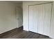 Bright bedroom features a closet, dark wood-look floors and white trim at 2871 Se 145 Pl, Summerfield, FL 34491