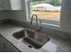 Kitchen sink and countertop with stainless steel faucet fixture and a view of the backyard at 2871 Se 145 Pl, Summerfield, FL 34491