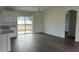 Living room with dark floors, white trim and sliding glass door access to the back yard at 2871 Se 145 Pl, Summerfield, FL 34491