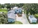 Aerial view of a charming home featuring a spacious driveway, lush landscaping, and a serene lakeside setting at 4237 Chambers St, Lake Wales, FL 33898