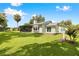 Expansive backyard with lush lawn, screened patio, and a charming exterior view of the home at 4237 Chambers St, Lake Wales, FL 33898