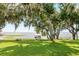 Picturesque backyard showcasing lush greenery, shade trees with Spanish moss, and waterfront views at 4237 Chambers St, Lake Wales, FL 33898