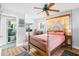 Bright bedroom with wood floors, ceiling fan, and a sliding door to a porch with lake views at 4237 Chambers St, Lake Wales, FL 33898