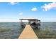 Waterfront view of a private covered dock with a boat lift on a sunny day at 4237 Chambers St, Lake Wales, FL 33898