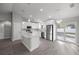 Bright kitchen features white cabinets, stainless appliances, island, and plenty of natural light at 53 Hemlock Trail, Ocala, FL 34472