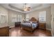 Main bedroom with trey ceiling, hardwood floors, and large windows at 5425 Se 44Th Cir, Ocala, FL 34480