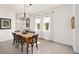 Dining room boasts tile floors, wood table, modern chandelier, and three large windows at 5430 Nw 46Th Lane Rd, Ocala, FL 34482