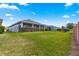 An expansive backyard features a screened porch and manicured privacy hedges, perfect for outdoor relaxation at 5616 Nw 39Th Ln, Ocala, FL 34482