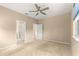 Neutral bedroom with carpet, walk-in closet, ceiling fan, and access to the en-suite bathroom at 5616 Nw 39Th Ln, Ocala, FL 34482