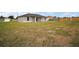 Large grassy backyard with home's rear exterior showing covered patio at 60 Walnut Dr, Ocala, FL 34480