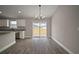 Open dining room with modern light fixture, sliding glass doors, and adjacent kitchen at 60 Walnut Dr, Ocala, FL 34480