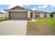 Charming one-story home featuring a two-car garage, lush lawn, and neutral exterior at 60 Walnut Dr, Ocala, FL 34480