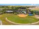 Expansive aerial view of community amenities, featuring a ball field, tennis courts, ample parking, and green spaces at 6376 Sw 97Th Terrace Rd, Ocala, FL 34481