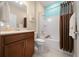 Well-lit bathroom featuring a wood vanity, shower and bath, and neutral wall paint at 6376 Sw 97Th Terrace Rd, Ocala, FL 34481